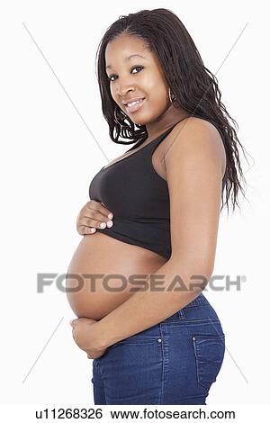 Portrait of happy young pregnant woman standing over white background View Large Photo Image Stock Photograph - Portrait of happy young pregnant woman standing over white background. Fotosearch