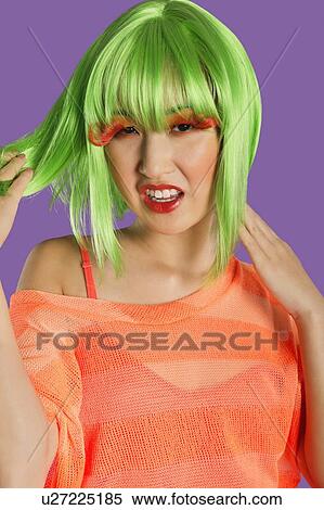 Stock Photography - Portrait of irritated young funky woman standing over purple background. Fotosearch