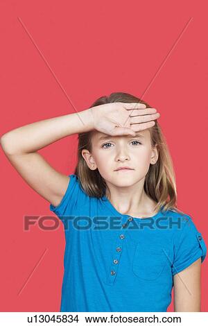 Portrait of sad girl checking self temperature against red background View Large Photo Image Picture - Portrait of sad girl checking self temperature against red background. Fotosearch