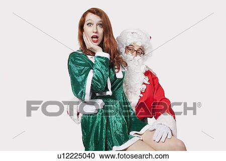 Portrait of Santa touching woman inappropriately against gray background View Large Photo Image Stock Image - Portrait of Santa touching woman inappropriately against gray background. Fotosearch