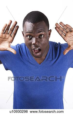 Portrait of shocked young man with palms open standing against white background View Large Photo Image Stock Photo - Portrait of shocked young man with palms open standing against white background. Fotosearch