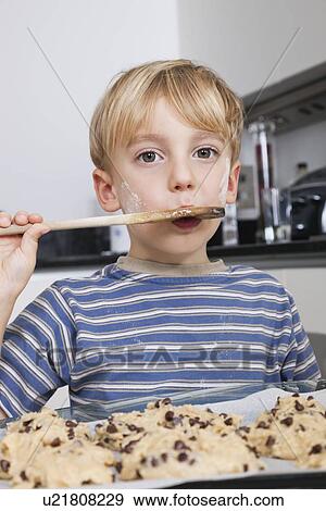 Portrait of young boy tasting spatula mix with cookie batter View Large Photo Image Stock Photo - Portrait of young boy tasting spatula mix with cookie batter. Fotosearch