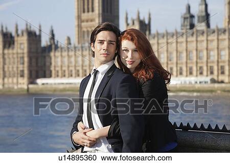 Portrait of young business couple standing together against Big Ben tower, London, UK View Large Photo Image Stock Image - Portrait of young business couple standing together against Big Ben tower, London, UK. Fotosearch
