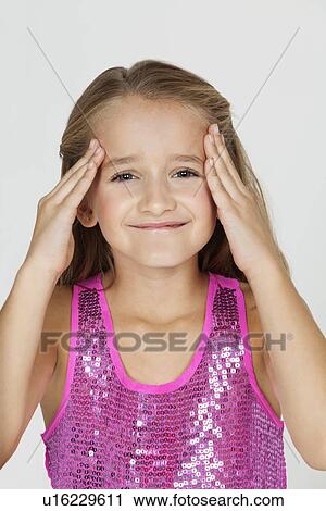 Portrait of young confused girl with hands on head against gray background View Large Photo Image Stock Image - Portrait of young confused girl with hands on head against gray background. Fotosearch