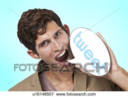 Portrait of young man holding tweet word bubble against white background View Large Photo Image Stock Photo - Portrait of young man holding tweet word bubble against white background. Fotosearch