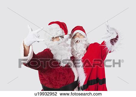 Portrait of young men in Santa costume gesturing over gray background View Large Photo Image Stock Image - Portrait of young men in Santa costume gesturing over gray background. Fotosearch