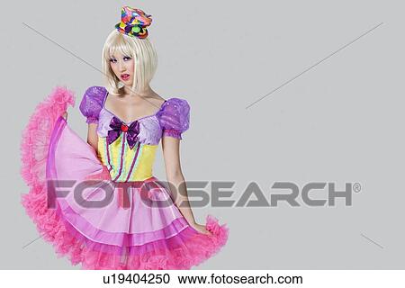 Portrait of young woman in doll's costume posing against gray background View Large Photo Image Stock Image - Portrait of young woman in doll's costume posing against gray background. Fotosearch