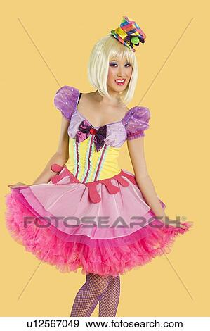 Portrait of young woman in doll's costume posing against yellow background View Large Photo Image Stock Photo - Portrait of young woman in doll's costume posing against yellow background. Fotosearch