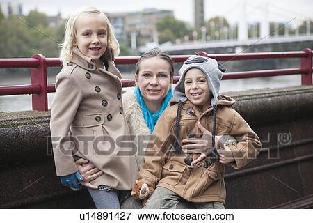 Stock Photo - Portrait of young woman with children smiling outdoors. Fotosearch