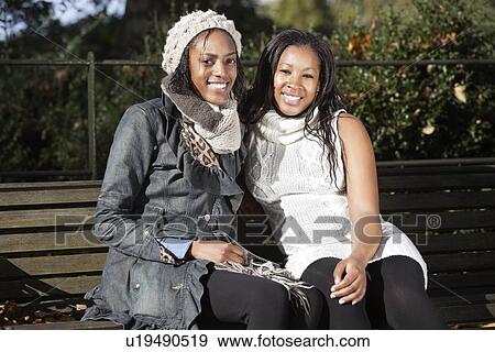 Portrait of young women relaxing on park bench View Large Photo Image Stock Photo - Portrait of young women relaxing on park bench. Fotosearch