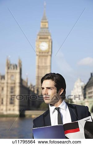 Picture - Thoughtful young businessman with book against Big Ben clock tower, London, UK. Fotosearch