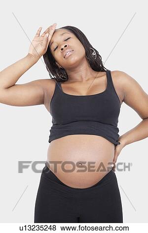 Stock Photo - Tired young pregnant woman over white background. Fotosearch