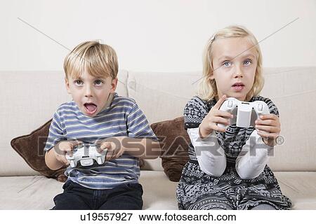 Stock Photo - Young brother and sister playing video game. Fotosearch