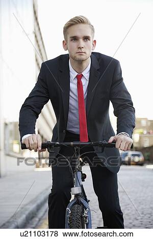 Young businessman riding bicycle on street View Large Photo Image Stock Photo - Young businessman riding bicycle on street. Fotosearch