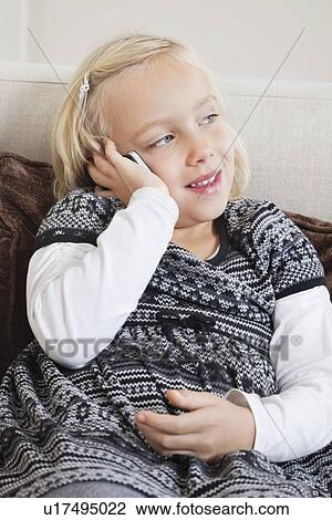 Young girl using cell phone on sofa View Large Photo Image Stock Image - Young girl using cell phone on sofa. Fotosearch