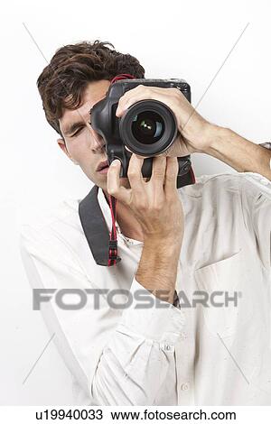 Young man taking photograph with vintage camera against white background View Large Photo Image Stock Image - Young man taking photograph with vintage camera against white background. Fotosearch