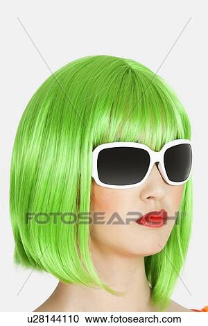 Young woman wearing green wig over gray background View Large Photo Image Stock Image - Young woman wearing green wig over gray background. Fotosearch