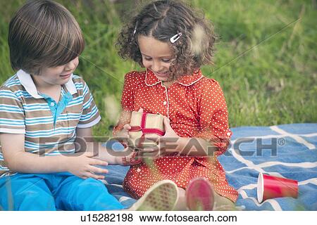 Boy giving gift at birthday picnic View Large Photo Image Stock Photo - Boy giving gift at birthday picnic. Fotosearch