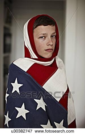 Stock Photo - Boy holding American flag indoors. Fotosearch