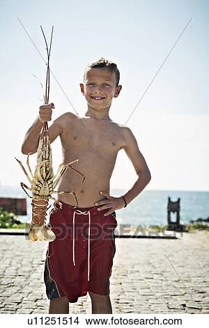 Picture - Boy holding freshly caught lobster. Fotosearch