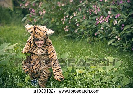 Stock Photo - Boy wearing tiger costume outdoors. Fotosearch