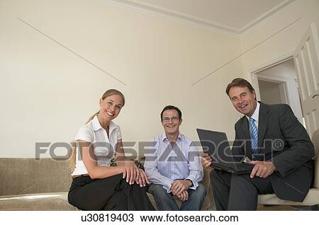 Business people sitting in living room View Large Photo Image Stock Image - Business people sitting in living room. Fotosearch