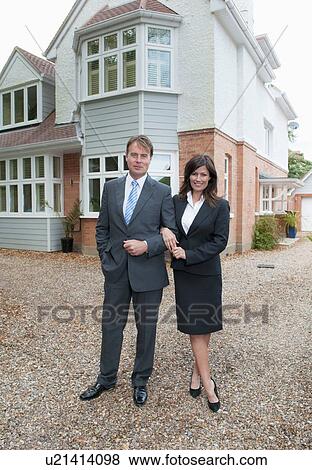 Stock Photo - Business people smiling outside house. Fotosearch