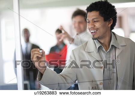 Stock Image - Businessman drawing graph on window. Fotosearch