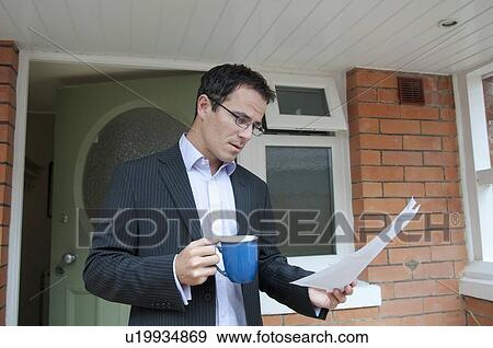 Businessman reading with cup of coffee View Large Photo Image Stock Photo - Businessman reading with cup of coffee. Fotosearch
