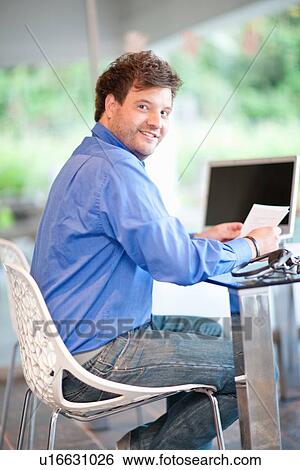 Businessman smiling at desk View Large Photo Image Stock Photograph - Businessman smiling at desk. Fotosearch