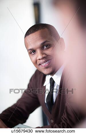 Stock Image - Businessman smiling in meeting. Fotosearch