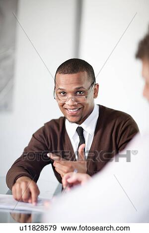 Stock Photo - Businessman smiling in meeting. Fotosearch