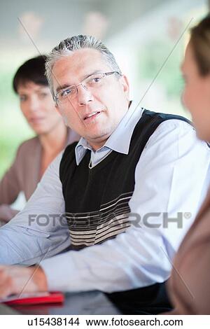 Picture - Businessman talking in meeting. Fotosearch