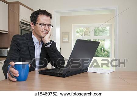 Businessman using laptop at breakfast View Large Photo Image Stock Image - Businessman using laptop at breakfast. Fotosearch