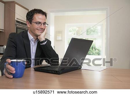 Businessman using laptop at breakfast View Large Photo Image Stock Image - Businessman using laptop at breakfast. Fotosearch
