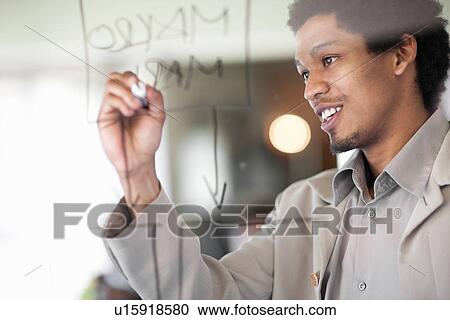 Stock Image - Businessman writing on window. Fotosearch
