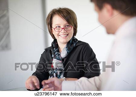 Businesswoman smiling in meeting View Large Photo Image Stock Photo - Businesswoman smiling in meeting. Fotosearch