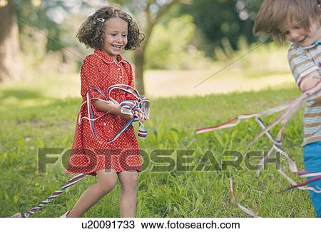 Stock Image - Children playing with ribbons outdoors. Fotosearch