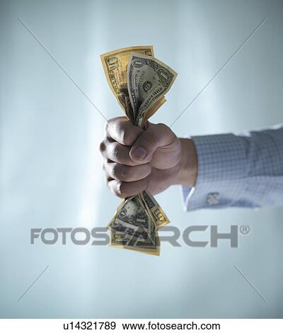 Close up of fist clenching dollar bills View Large Photo Image Stock Photo - Close up of fist clenching dollar bills. Fotosearch