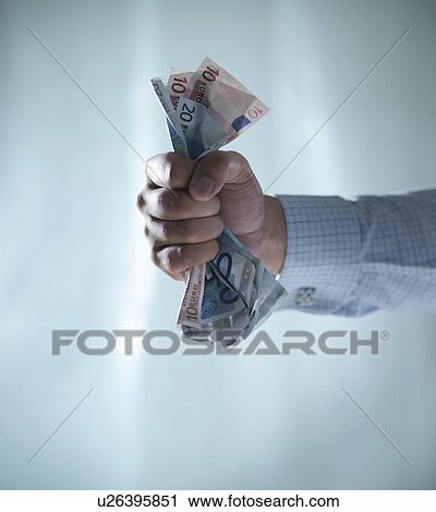 Close up of fist clenching Euro bills View Large Photo Image Stock Image - Close up of fist clenching Euro bills. Fotosearch