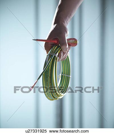 Stock Photography - Close up of hand holding cords. Fotosearch