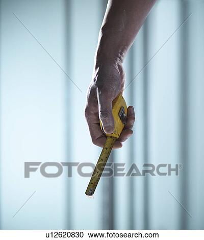 Close up of hand holding measuring tape View Large Photo Image Stock Image - Close up of hand holding measuring tape. Fotosearch