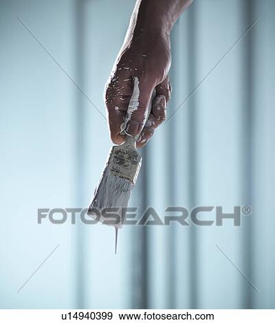 Stock Photo - Close up of hand holding paintbrush. Fotosearch