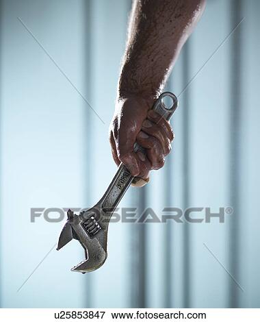 Stock Photo - Close up of hand holding wrench. Fotosearch