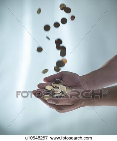 Close up of hands catching pile of coins View Large Photo Image Stock Photo - Close up of hands catching pile of coins. Fotosearch