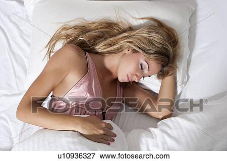 Stock Photo - Close up of woman sleeping in bed. Fotosearch