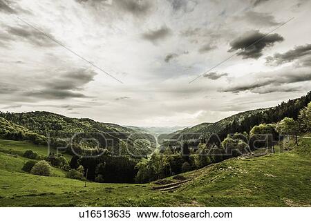 Stock Photography - Clouds over grassy rural landscape. Fotosearch