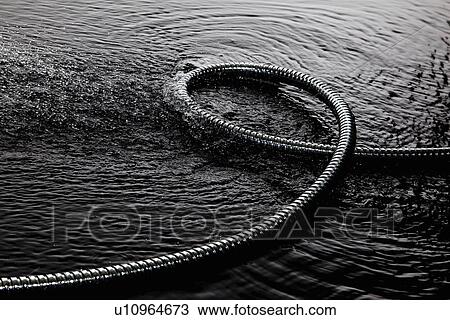 Stock Image - Coiled metal tube in water. Fotosearch