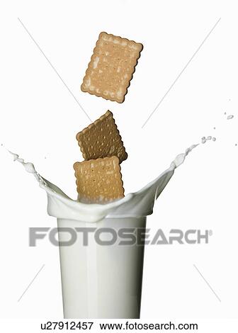 Cookies splashing into glass of milk View Large Photo Image Stock Photo - Cookies splashing into glass of milk. Fotosearch