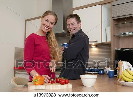 Couple cooking together in kitchen View Large Photo Image Stock Photo - Couple cooking together in kitchen. Fotosearch
